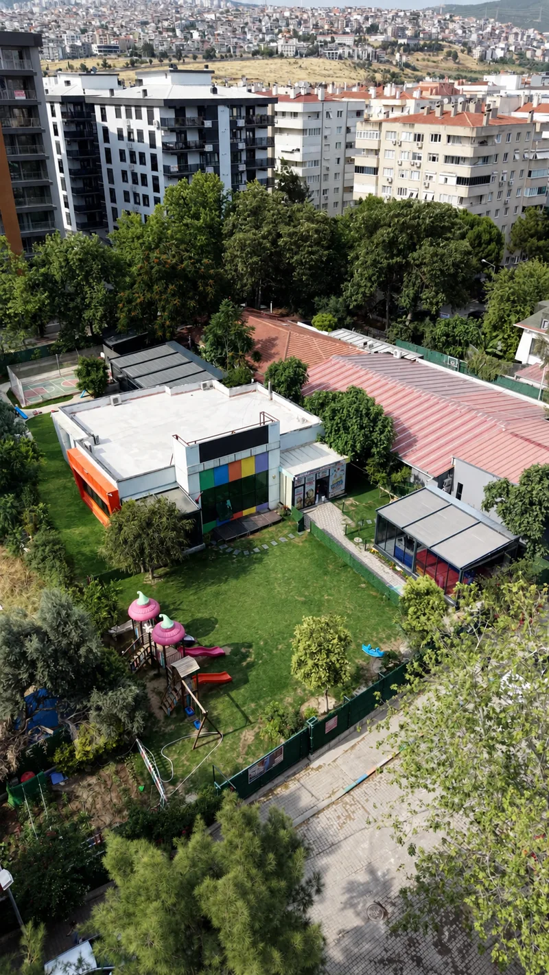 Okul binası, ağaçlar ve bahçenin yukarıdan görünümü